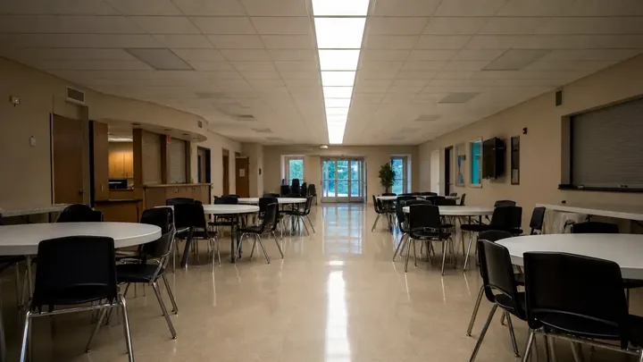 Empty church lobby with a welcome table lit by one row of lights